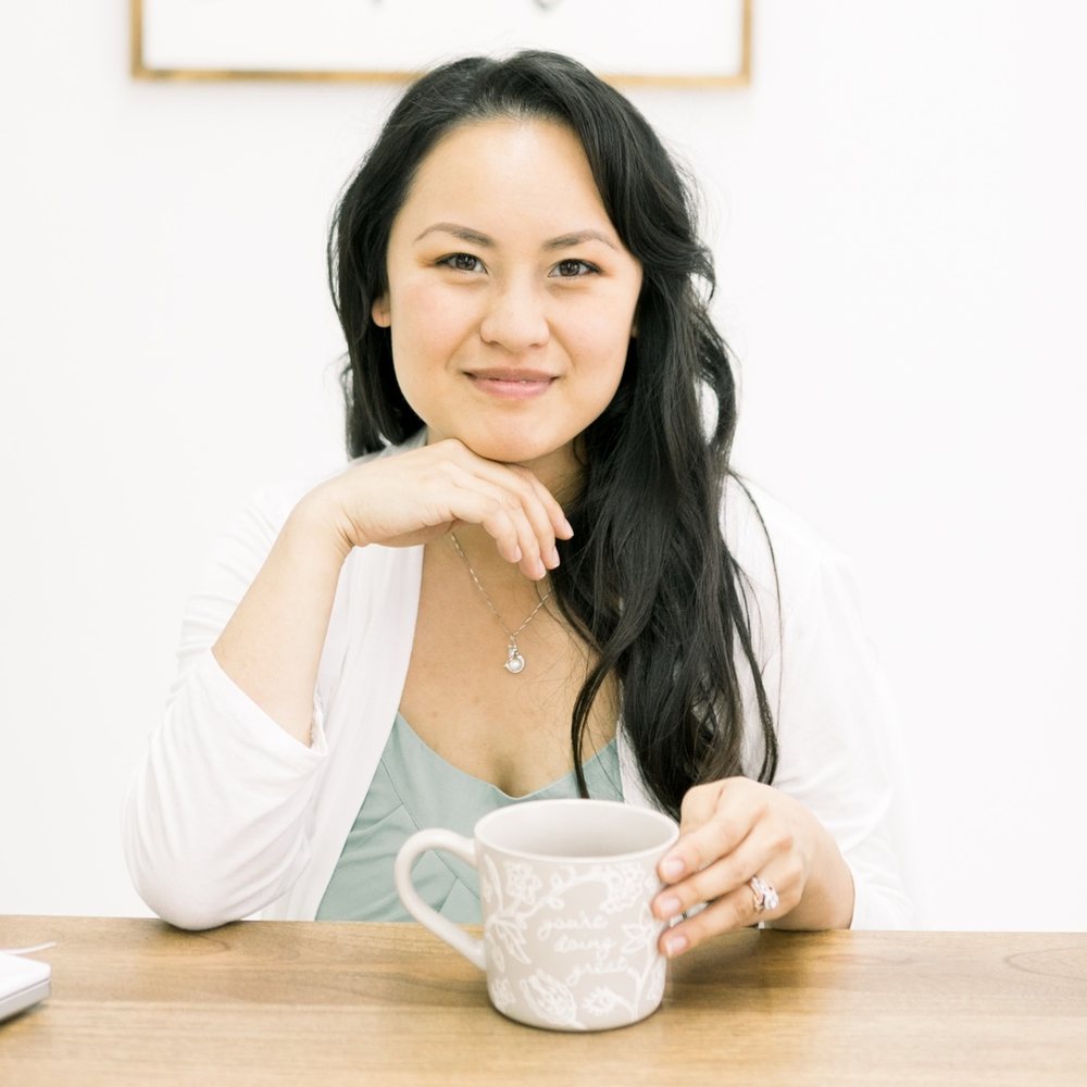 Serena Kretchmer smiling at her desk with a coffee mug.